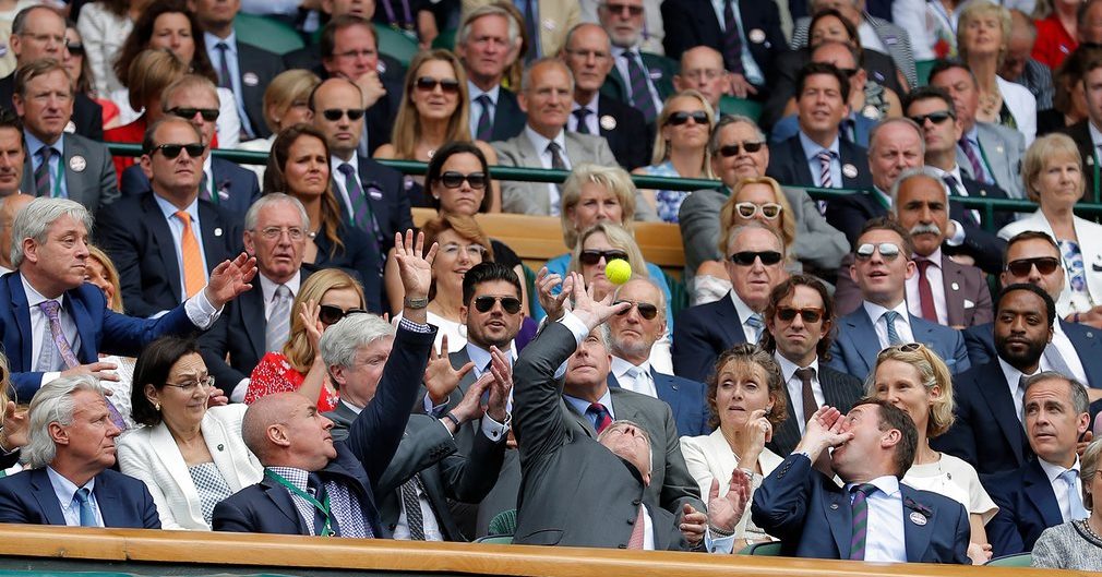 Prince Andrew tries to catch a ball deflected into the Royal Box during the Roger Federer v Milos Raonic semi